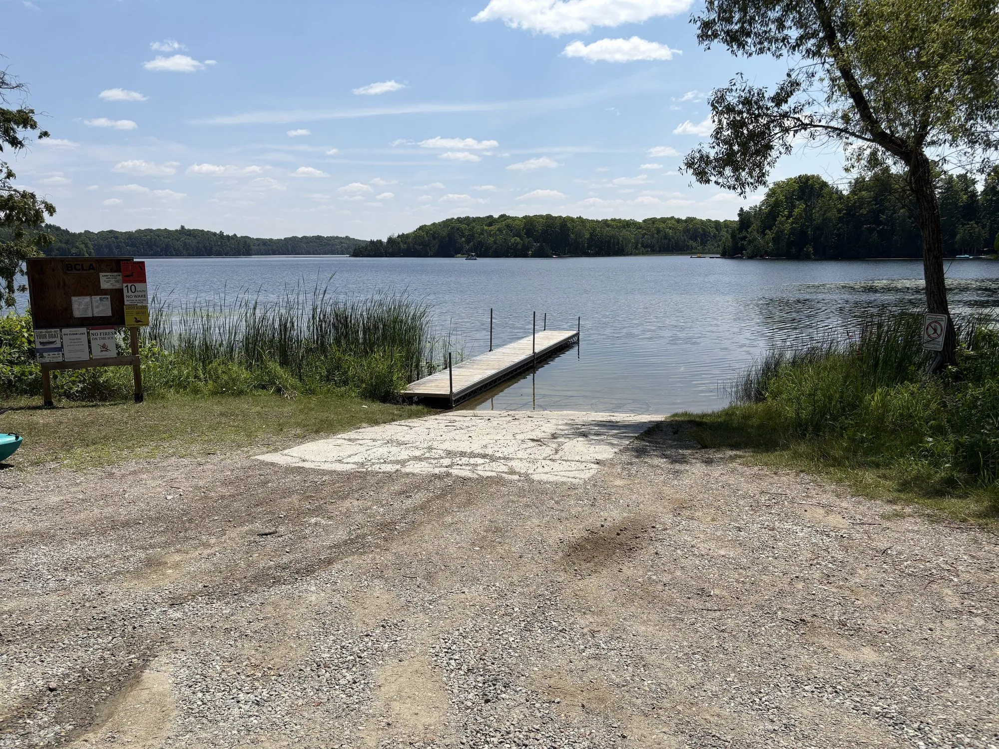 The gravel launch and floating dock on Big Clear Lake at Arden Beach, reeds along the shoreline